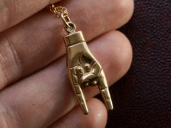 thumbnail of Detail of vintage gold hand pendant gesturing the sign of the horns, shown held in hand.
