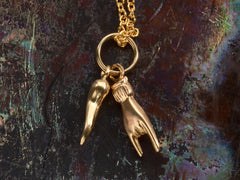 thumbnail of Reverse side of a pair of vintage gold Italian charms: a horn and a hand gesturing the sign of the horns. Shown on dark colorful background.