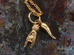 thumbnail of A pair of vintage gold Italian charms: a horn and a hand gesturing the sign of the horns. Shown on dark colorful background.