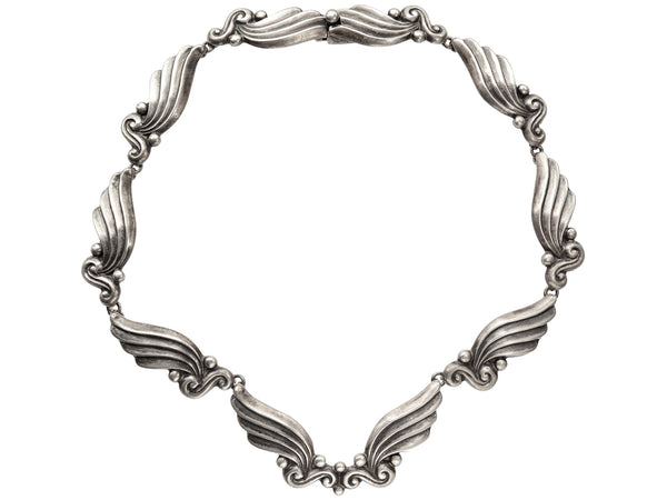Silver vintage Margot de Taxco necklace with wing-like design on a white background