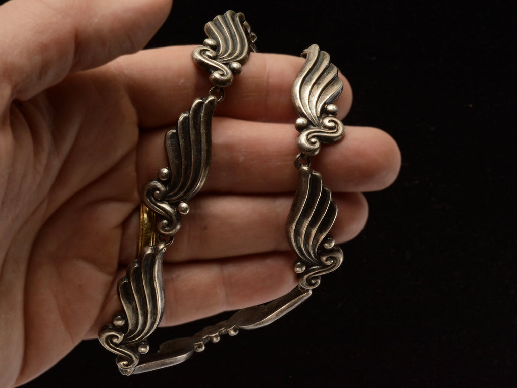 Silver vintage Margot de Taxco necklace with wing-like design held in hand.