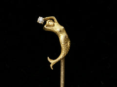 thumbnail of Detail of c1890 Yellow Gold Mermaid Stick Pin with a diamond, shown on black background.