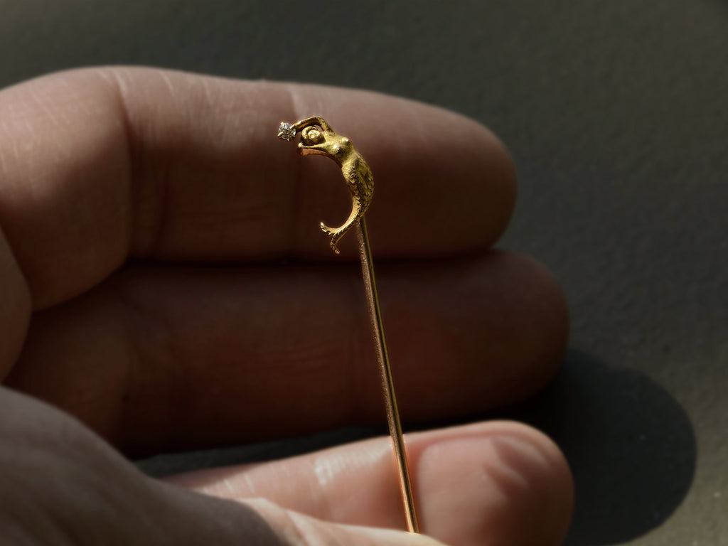 c1890 Yellow Gold Mermaid Stick Pin with a diamond, shown on held in hand