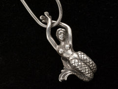 thumbnail of Detail of vintage silver mermaid pendant on snake chain, on black background.
