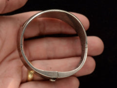 thumbnail of Side profile of a vintage silver bracelet with inset oval black onyx polka-dots, shown held in hand.
