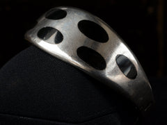 thumbnail of Angled view of a vintage silver bracelet with inset oval black onyx polka-dots, shown on black background