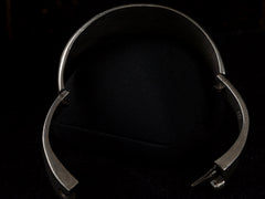 thumbnail of Side profile of a vintage silver bracelet with inset oval black onyx polka-dots, shown hinged open on black background