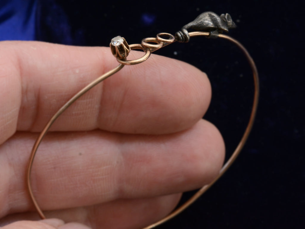 Left side view of c1890 Diamond Mouse Bracelet in hand for scale