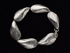 thumbnail of Silver bracelet with mussel shell links, on black background. Shown laid in a circle