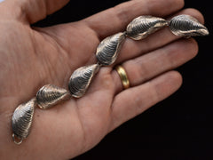 thumbnail of Silver bracelet with mussel shell links, on hand.
