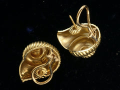 thumbnail of Reverse side of of yellow gold ammonite shaped earrings, showing posts and omega backs, on dark background.