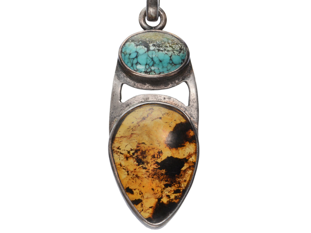 Vintage silver pendant with oval turquoise and pear shaped tortoiseshell, on white background.
