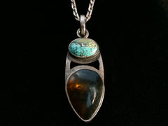 thumbnail of Silver pendant with oval turquoise and pear shaped tortoiseshell on black background.