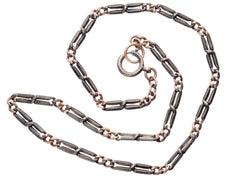 thumbnail of An antique chain of alternating silver and black striped links and gold filled links. Shown spiraled on white background.