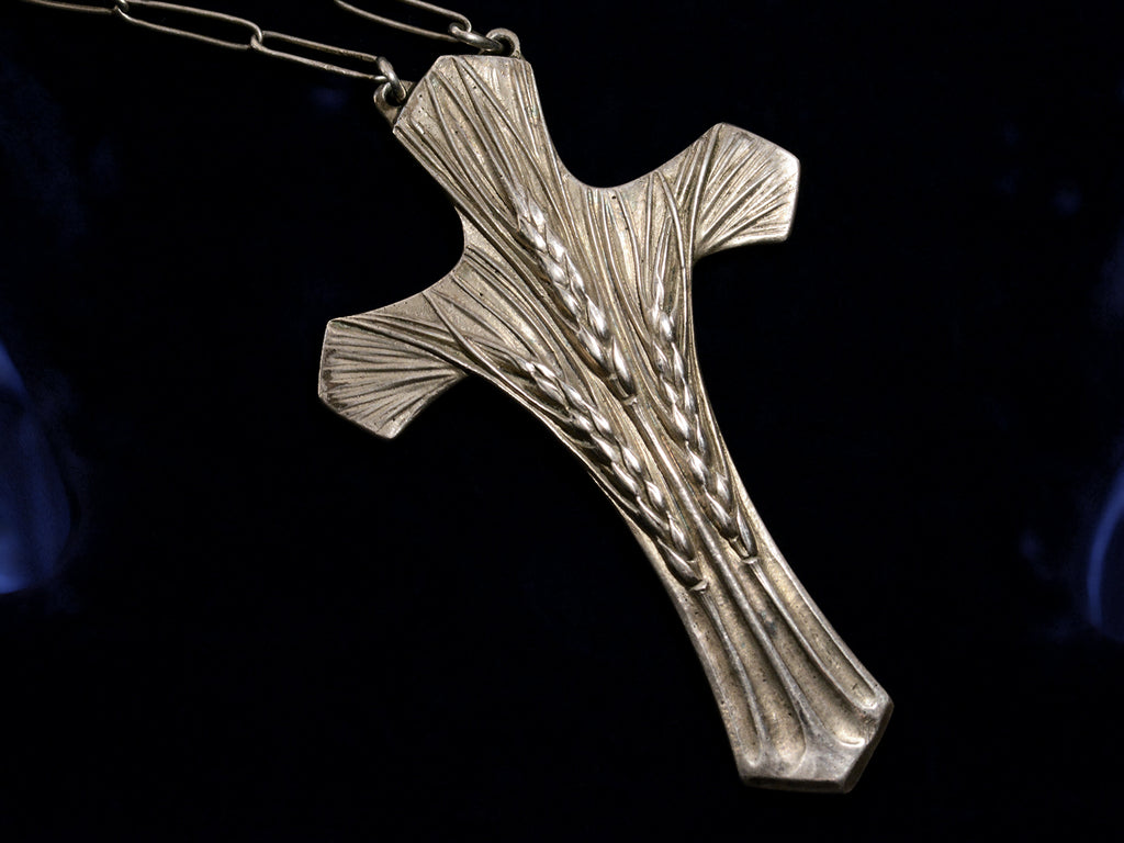 Detail view of c1900 Art Nouveau Cross with wheat design in silver (shown on black background)