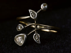 thumbnail of Angled view of an antique Art Nouveau gold and silver ring with rose cut diamonds in a floral design. Shown on dark background.