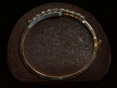 thumbnail of Side profile of a platinum topped yellow gold Art Nouveau bracelet with rows of old European cut and rose cut diamonds, shown on dark textured background.