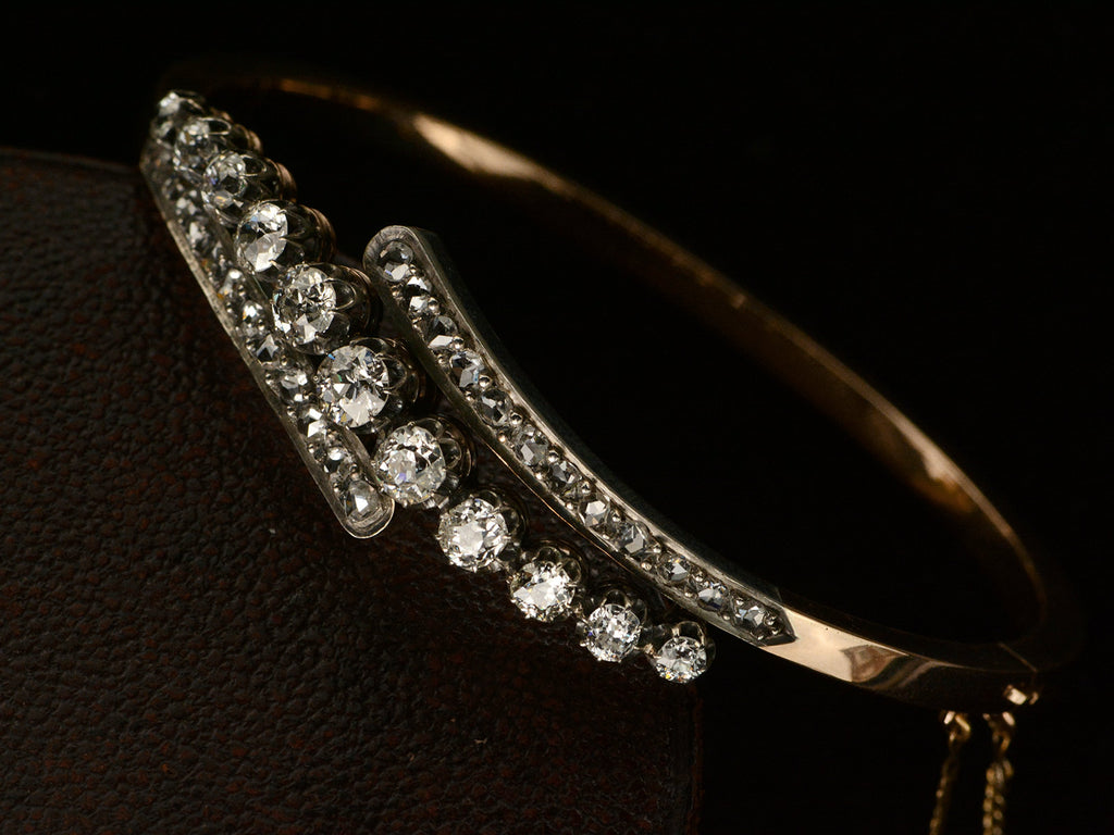 Close up, angled view of platinum topped yellow gold Art Nouveau bracelet with rows of old European cut and rose cut diamonds, shown on dark background.