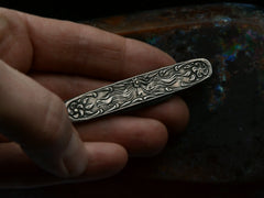 thumbnail of Art Nouveau silver pocket knife with imagery of a woman and flowers, shown held in hand.