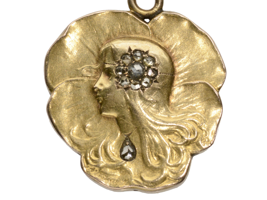 c1910 Art Nouveau yellow gold pansy shaped pendant with the profile of a woman (shown on white background)