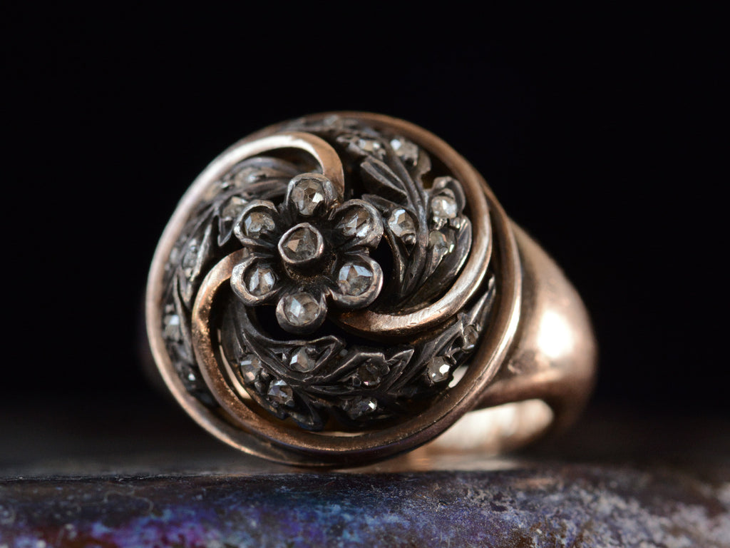 Right angled view of c1890 Art Nouveau Ring with Circular Top of Spiraling Rose Cut Diamond Silver Vines in a Gold Frame (shown on dark background)