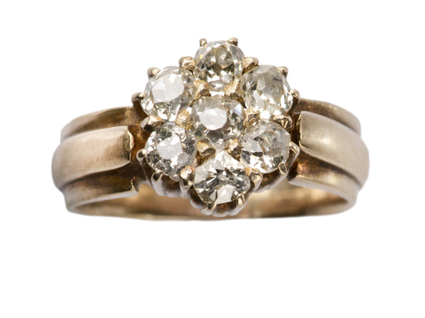 Antique rosy-yellow gold ring with cluster of old mine cut diamonds, on white background.