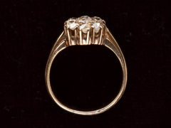 thumbnail of Side profile view of antique rosy-yellow gold ring with cluster of old mine cut diamonds, on black background.