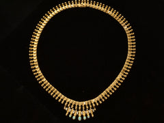 thumbnail of A c1930 Victorian-style 18K rosy-yellow gold collar with a small front bib of opals and diamonds, shown on black background.
