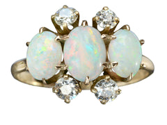 thumbnail of A vintage gold ring featuring three oval white opal stones and four round diamonds, set in gold against a plain white background.