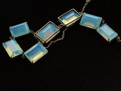 thumbnail of Detail view of reverse side of vintage c1950 silver necklace with a bib of rectangular opalescent glass stones, shown on black background.