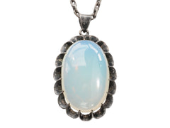 thumbnail of Detail of a vintage oxidized silver necklace with an oval opaline glass pendant, shown on white background.