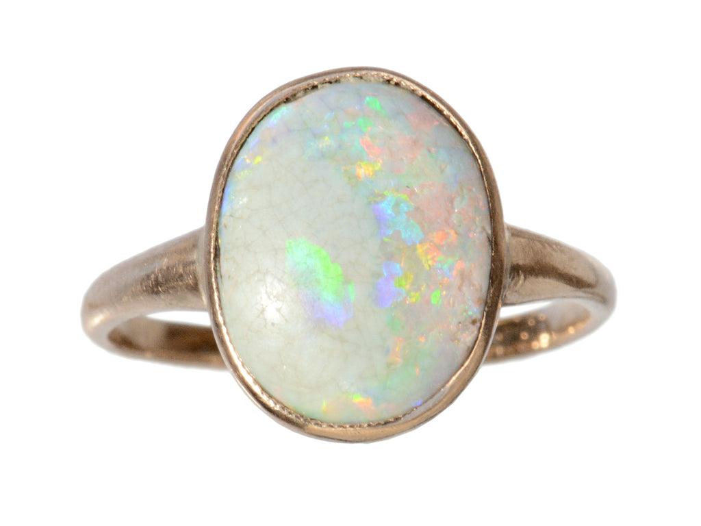 A c1920 oval opal ring in rosy 10K gold, shown on white background.