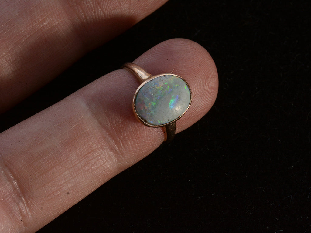 Ac1920 oval opal ring in rosy 10K gold, shown on finger for scale