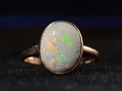 thumbnail of Front view of c1920 oval opal ring in rosy 10K gold, shown on black background.