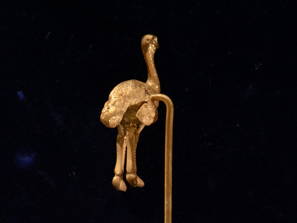 Rear view of Antique yellow gold ostrich stick pin (on black background)