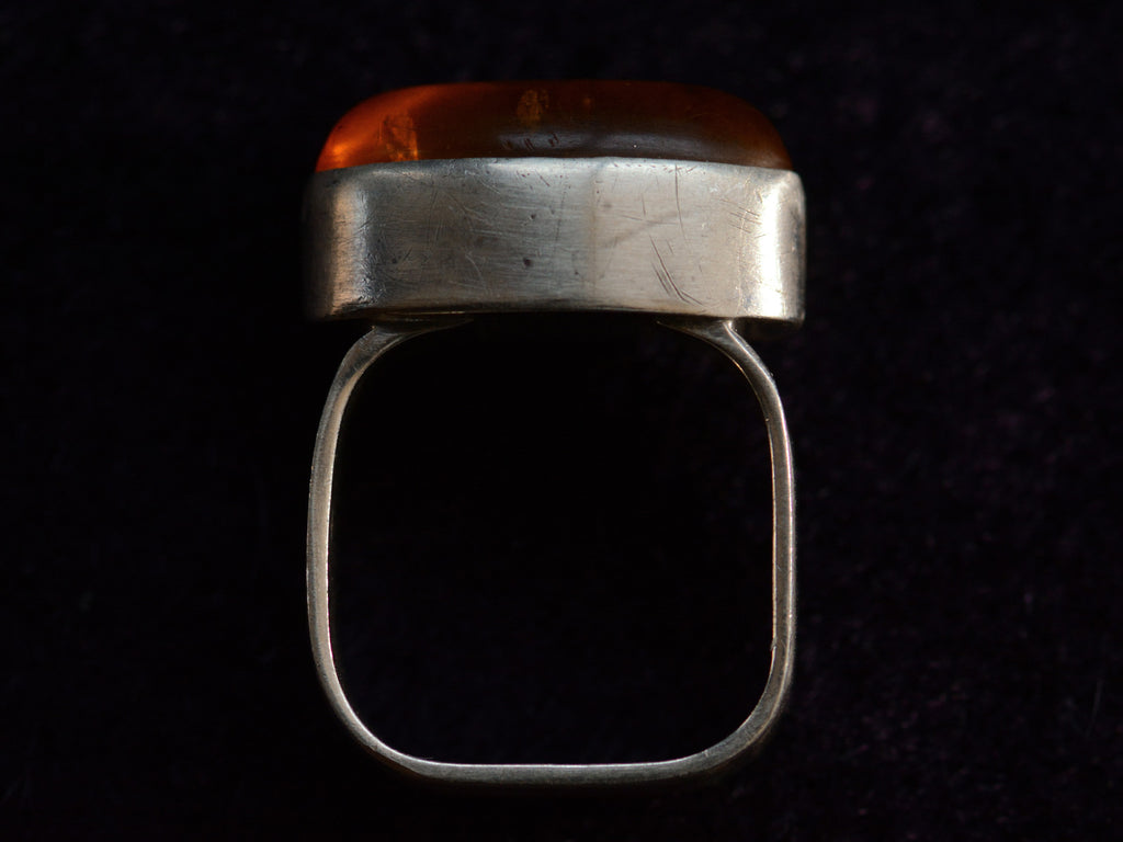 Side profile view of c1980 Oval Amber Ring in Sterling Silver (on dark background)