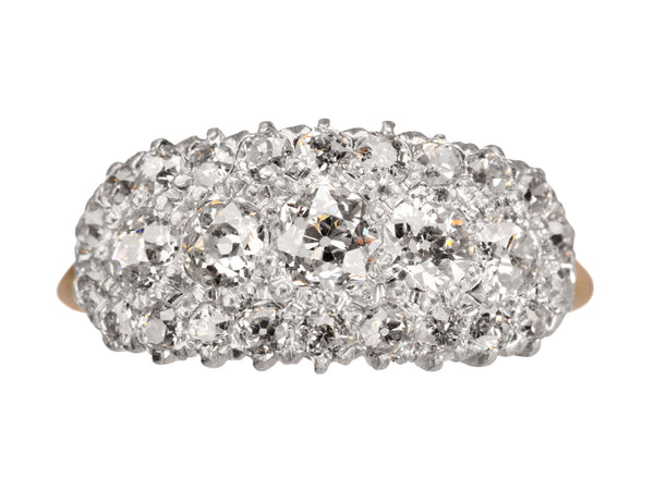 Antique c1900 ring with an oval cluster of round old European cut diamonds set in platinum-topped 14K yellow gold, shown on white background.