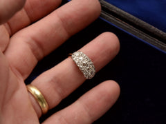 thumbnail of Front view of antique c1900 ring with an oval cluster of round old European cut diamonds set in platinum-topped 14K yellow gold, shown on finger