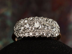 thumbnail of Front view of antique c1900 ring with an oval cluster of round old European cut diamonds set in platinum-topped 14K yellow gold, shown on dark background.