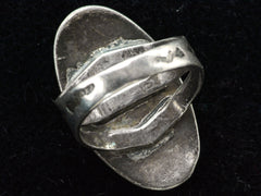 thumbnail of Reverse inside view of a Navajo ring with a large dark olive green cabochon bezel set in silver with a decorative stamped split shank. Shown on black background.