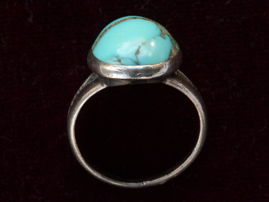 Side profile view of c1950 Navajo Turquoise Ring in silver on black background.