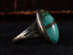 thumbnail of Left side view of c1950 Navajo Turquoise Ring in silver on black background.