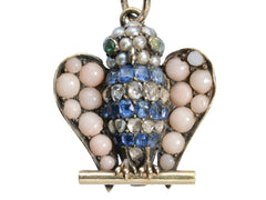 thumbnail of A owl pendant set with pale pink coral, sapphires, diamonds, pearls, and emeralds (shown on white background)