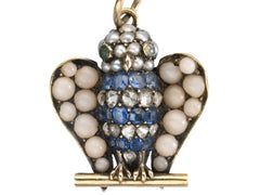 thumbnail of Antique c1890 owl pendant with pale coral wings, a pearl head, emerald eyes and a body of sapphires and rose cut diamonds. Shown on white background.
