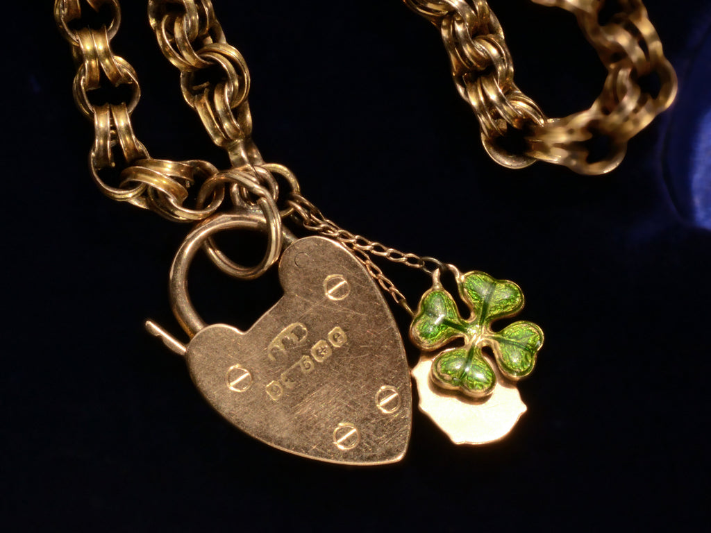 1904 Gold Padlock Bracelet with Ladybug and Clover Charms (detail of reverse side of padlock showing English hallmarks on black background)