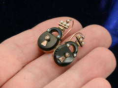 thumbnail of Front side of c1880 Black Onyx and Pearl Padlock Earrings , shown hand for scale