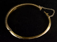 thumbnail of Side view of a narrow gold Victorian Pearl Bracelet with intricate Etruscan Revival granulation detailing, shown with clasp open on dark background.