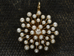 thumbnail of An antique starburst-form yellow gold pendant with pearls radiating out from a center diamond, shown on dark textured background.