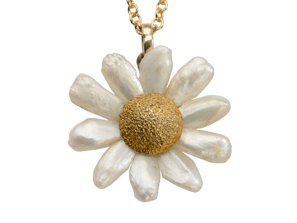 An antique daisy pendant with textured gold and pearl petals, shown on white background.