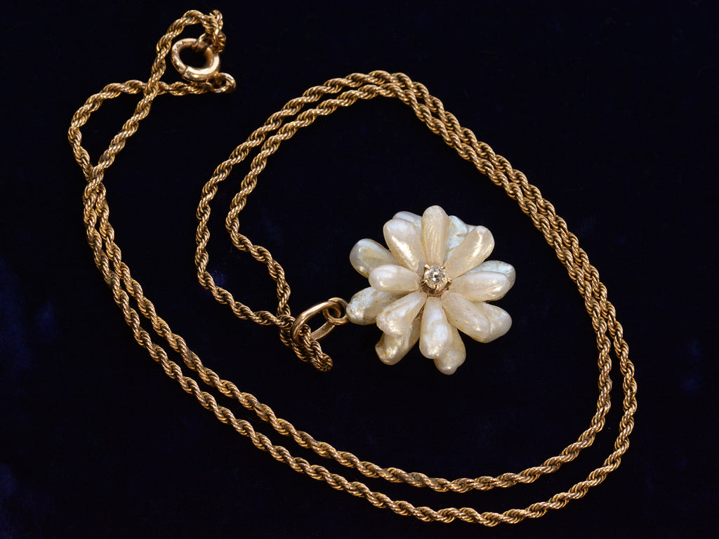 c1910 Pearl Flower Necklace (shown with complete chain spiraled around pendant, on dark blue background)